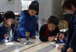 ペンライトを使ってソーラーミニカーを走らせる子供たち（市生涯学習フェスティバル「まなトピア」）