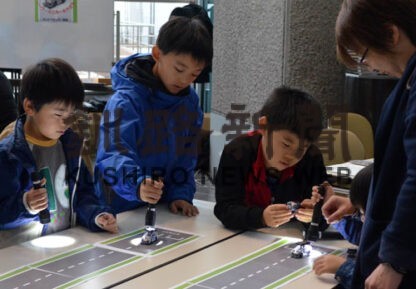 ペンライトを使ってソーラーミニカーを走らせる子供たち（市生涯学習フェスティバル「まなトピア」）